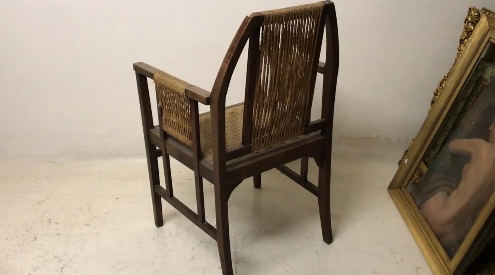 Fauteuil de bureau ancien avec dossier haut et bras dans un environnement clair.