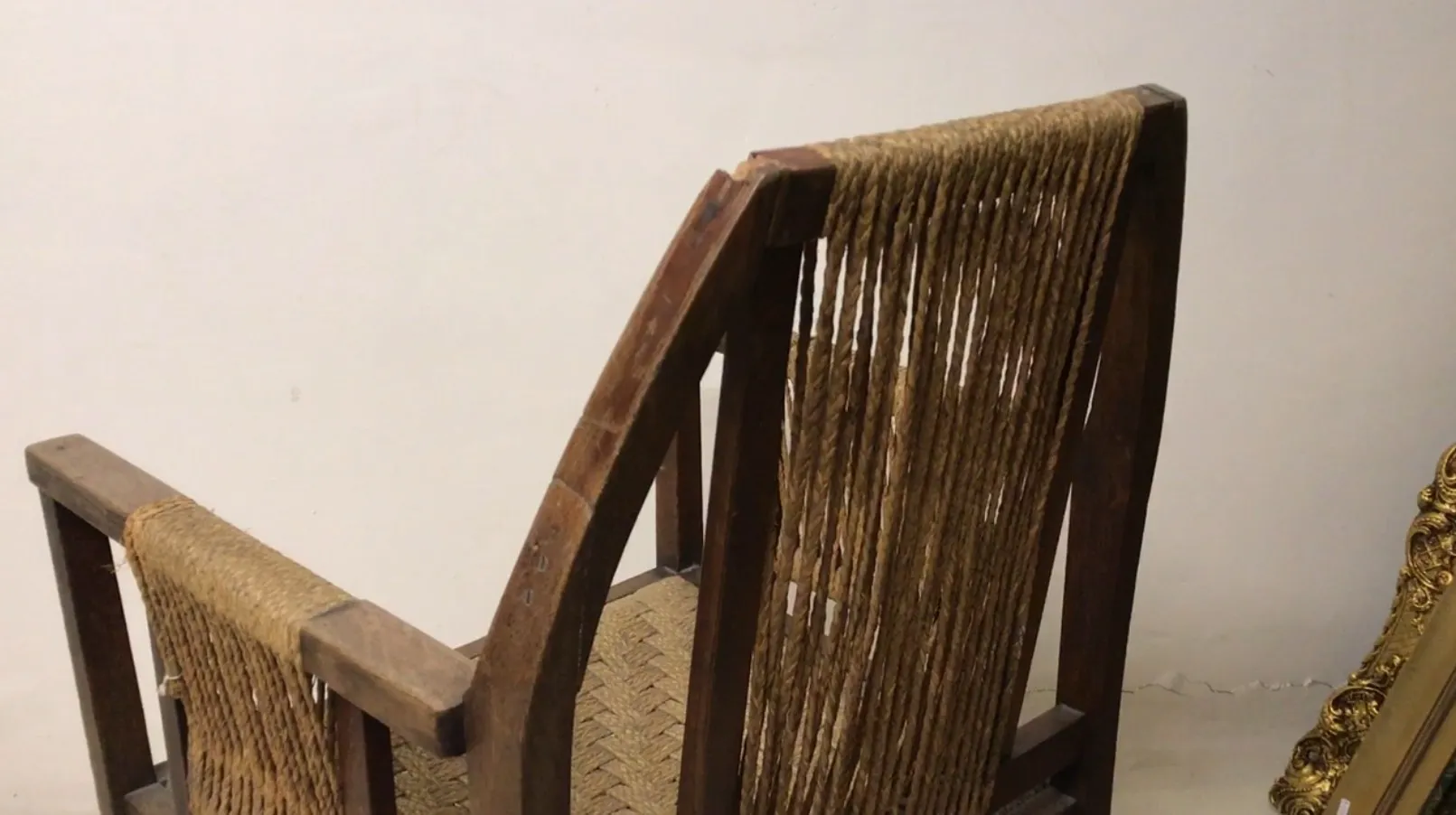 Antique desk chair with woven backrest in a light setting.