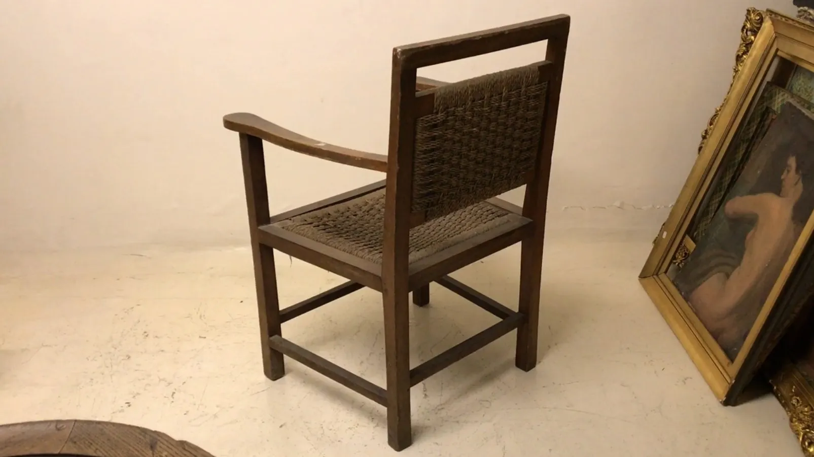 fauteuil antique avec bras, fond clair, cadre simple.