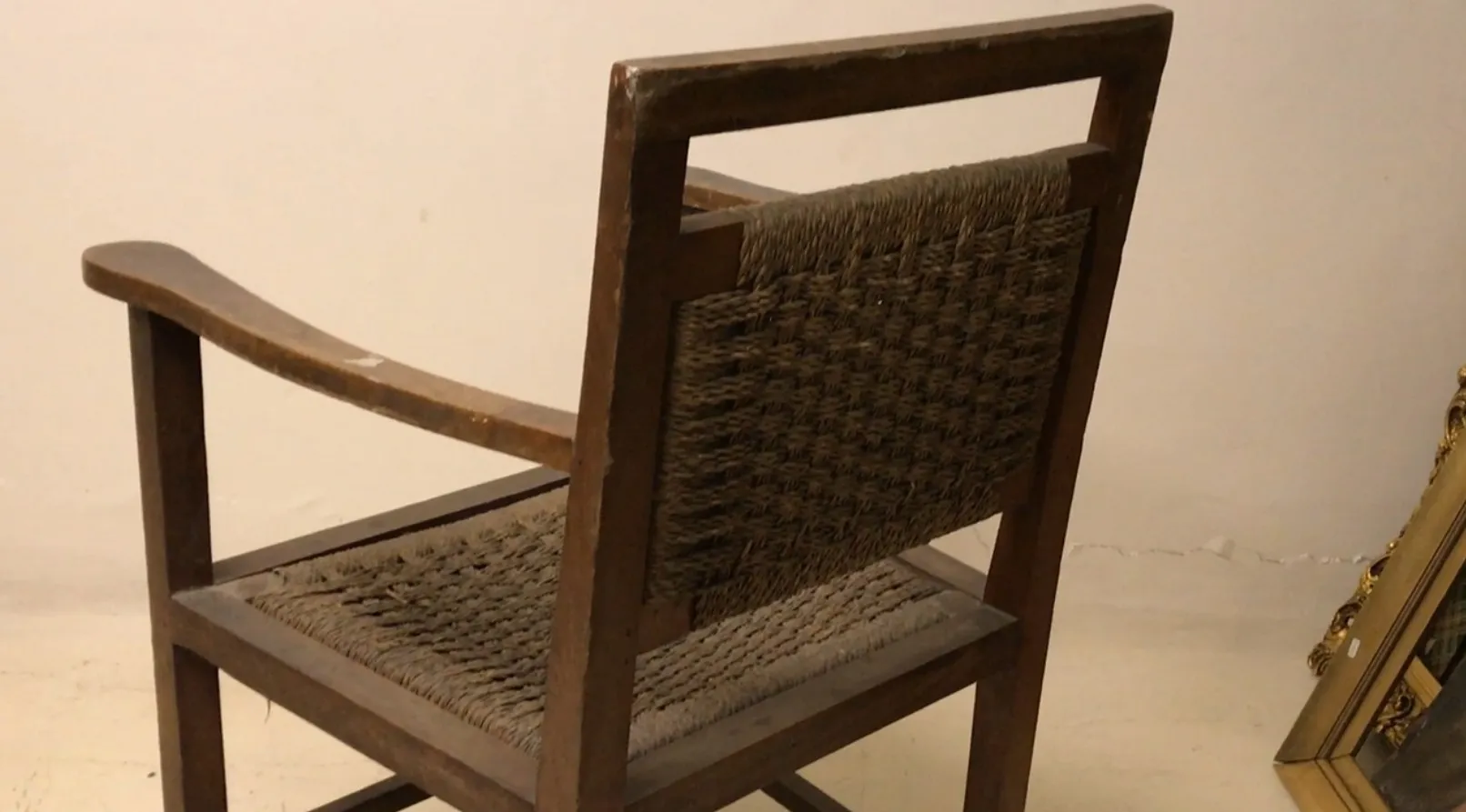 Antique armchair with backrest and arms, decorative background.