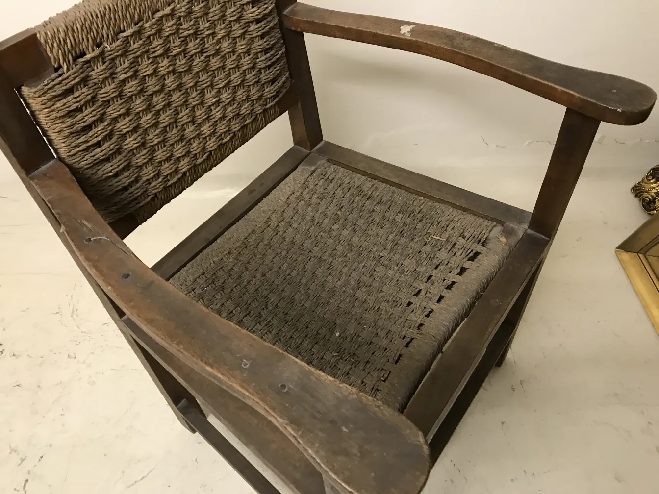 Fauteuil ancien de style Art Nouveau avec des détails tressés, fond neutre.