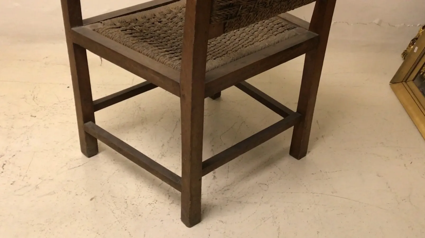 Fauteuil ancien avec design accueillant dans un cadre neutre.