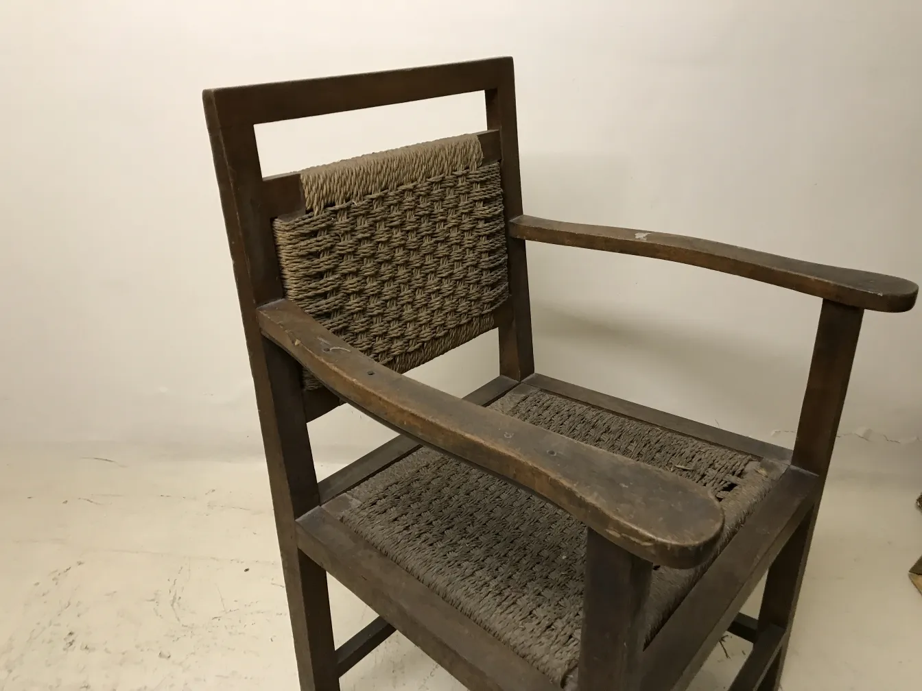 Antiker Sessel mit klassischem Armdesign, neutraler Hintergrund.