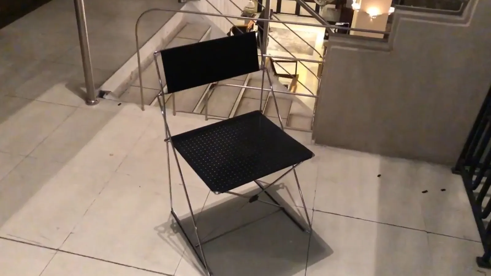 Deux chaises anciennes au design simple dans un cadre élégant, avec des escaliers en arrière-plan.