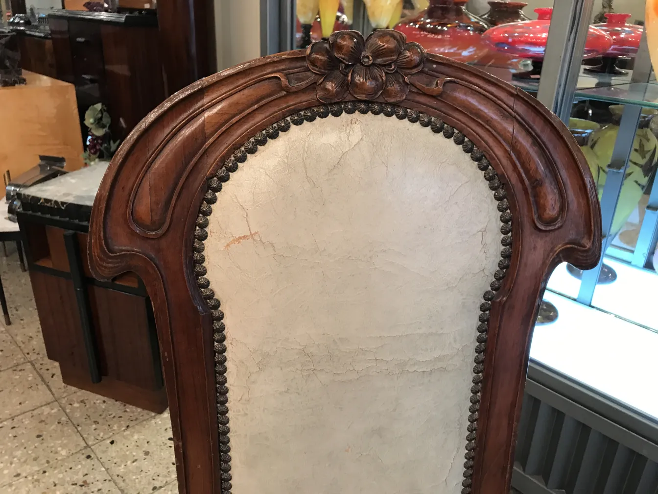 silla antigua con detalle en la parte superior, rodeada de otros objetos