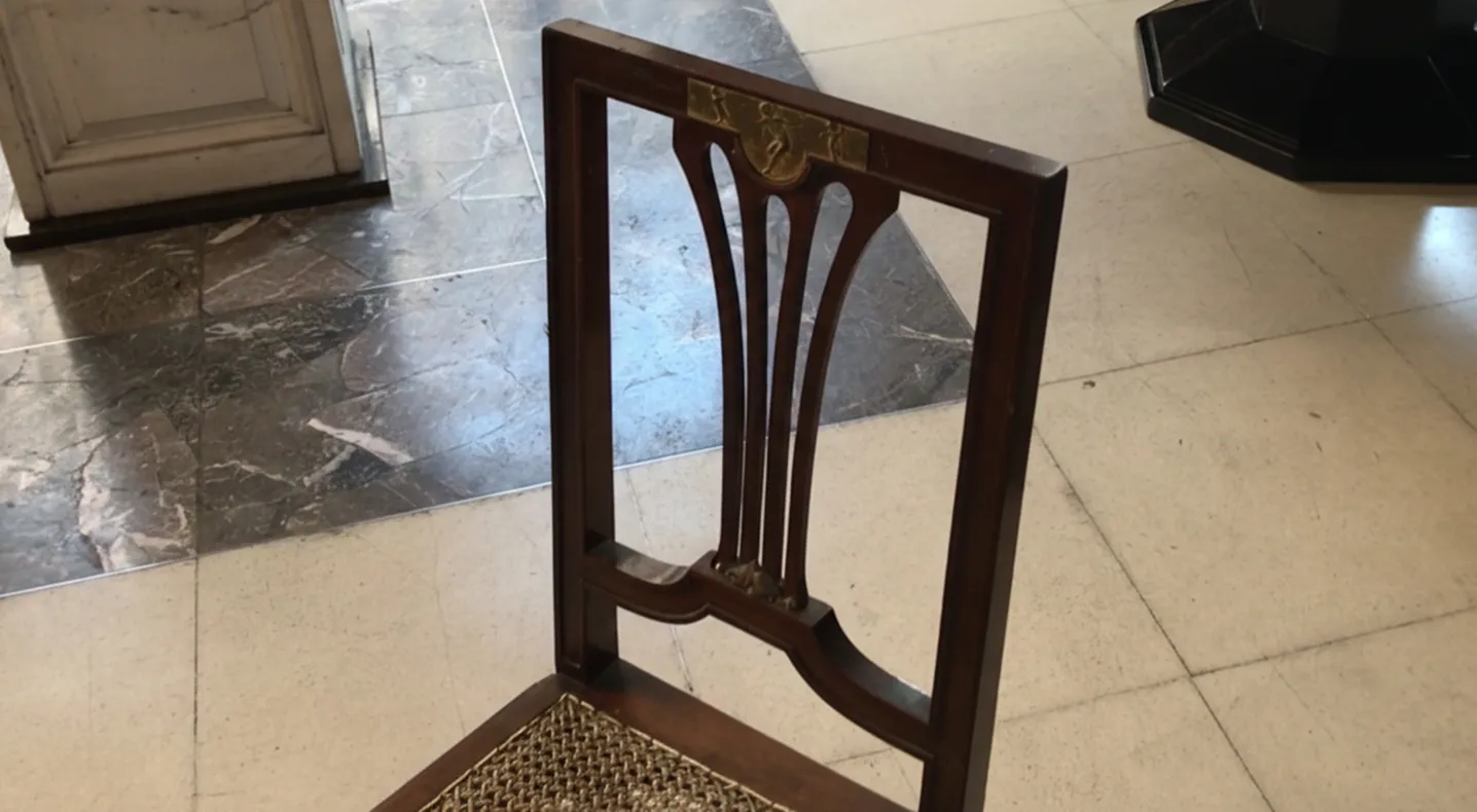 Detail of 2 antique chairs with a classic and elegant design in a neutral setting.