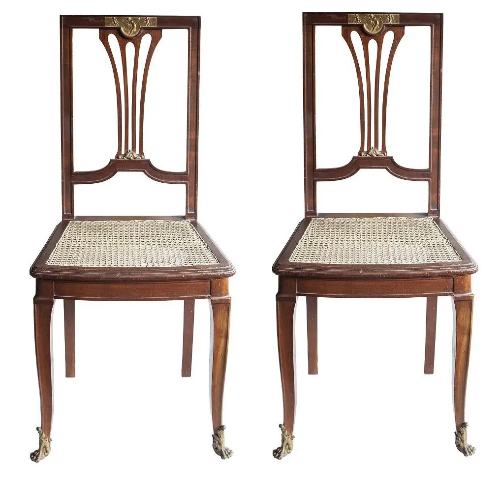 Conjunto de dos sillas antiguas de diseño clásico, detalles decorativos.