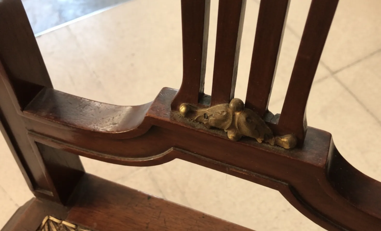 Detail von antiken Stühlen mit goldenen Verzierungen am Rahmen.