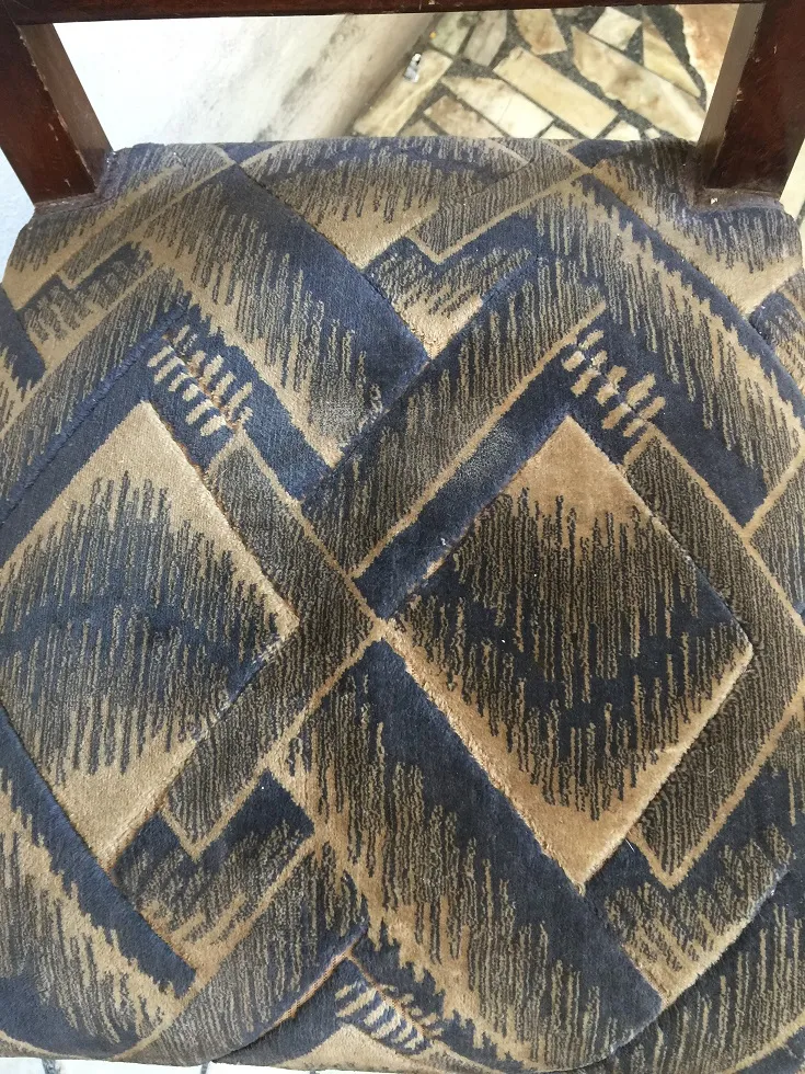 Two antique Art Deco chairs featuring geometric patterns in a classic setting.