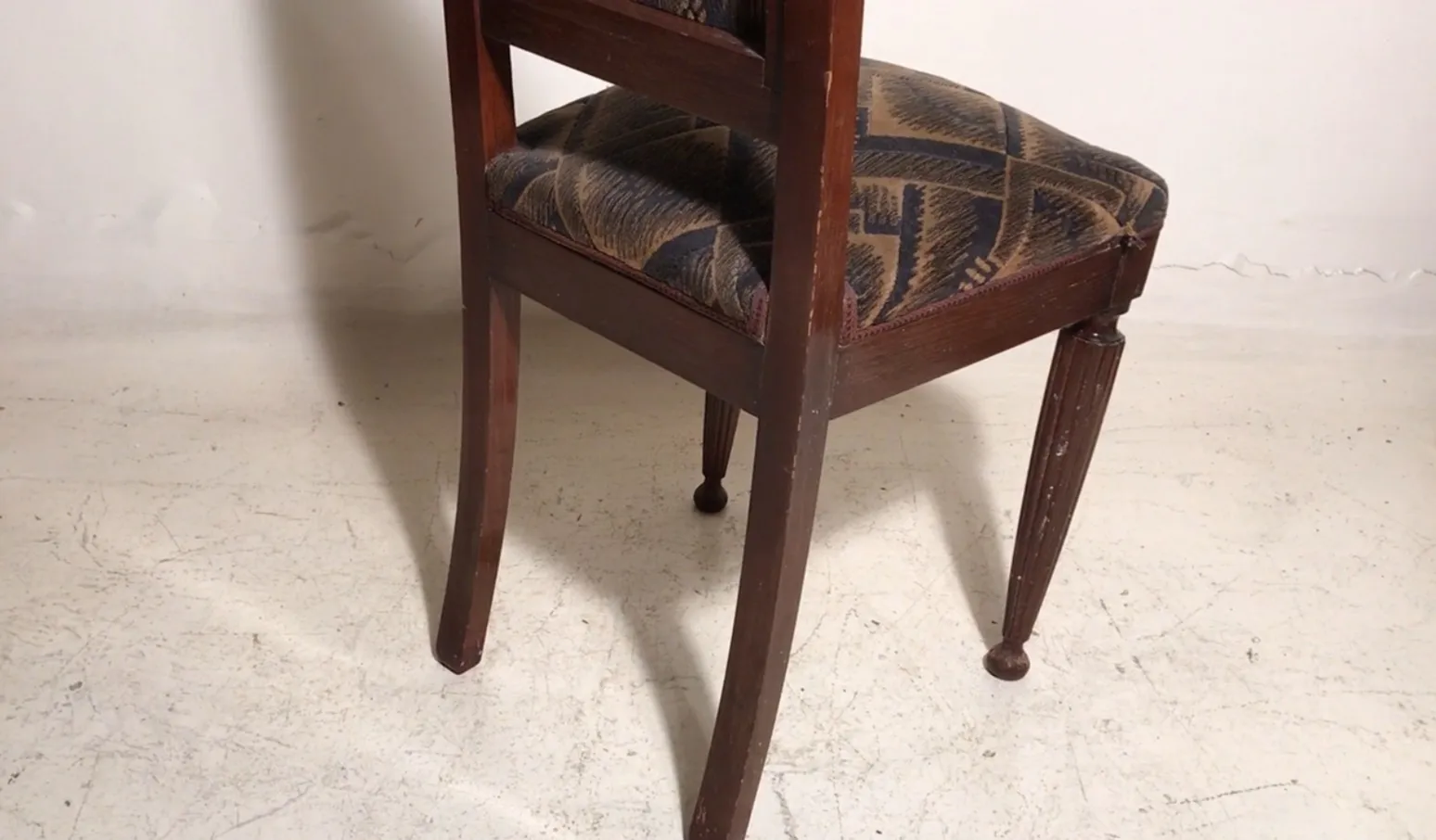 Two antique chairs with worn upholstery, perfect for restoration. Neutral background.
