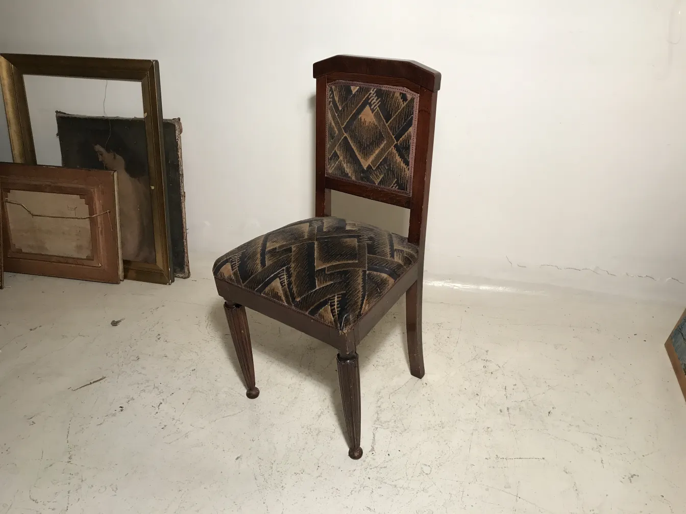 اثنان من الكراسي القديمة في بيئة مع إطارات وفن