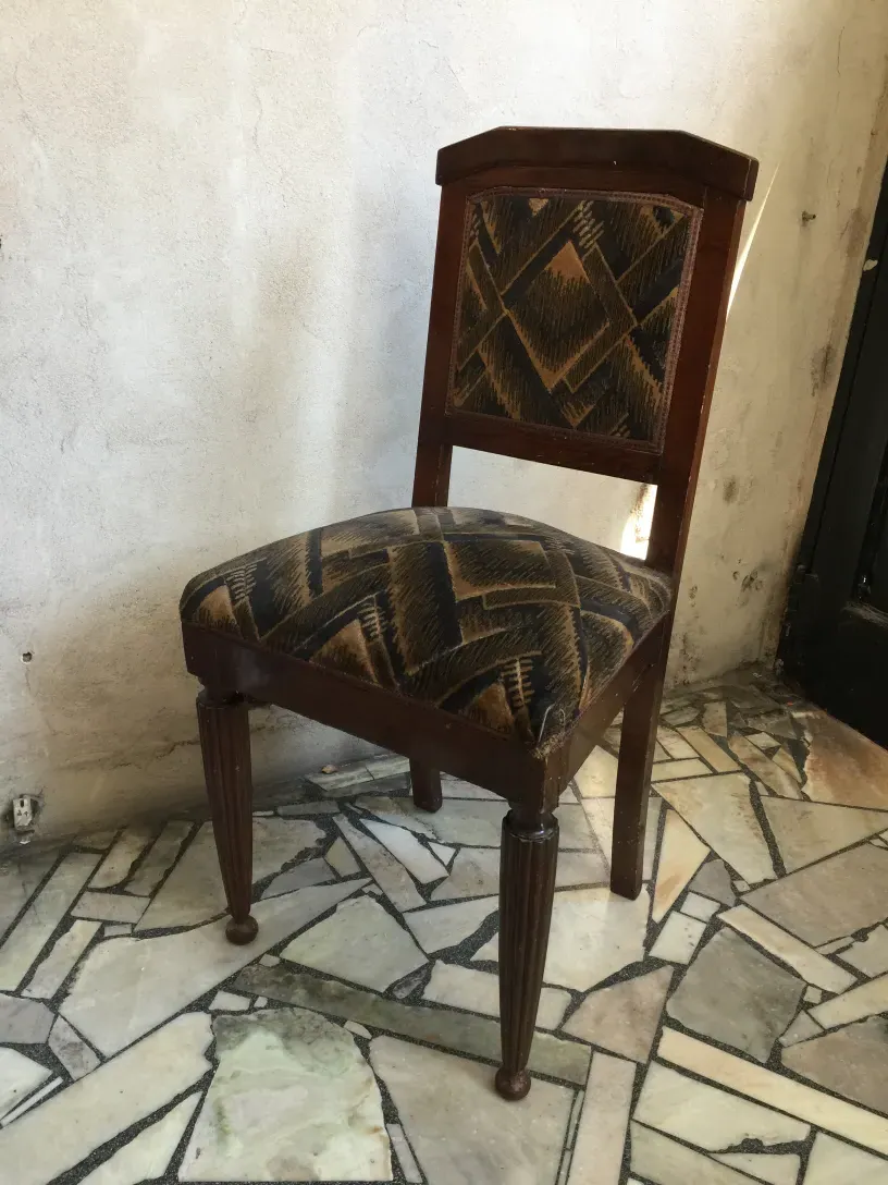 Two antique chairs in art deco style, featuring an attractive design, ready for restoration, set against a stone floor background.
