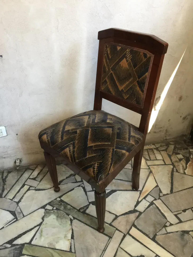 Zwei antike Stühle mit geometrischem Design in einer rustikalen Umgebung.