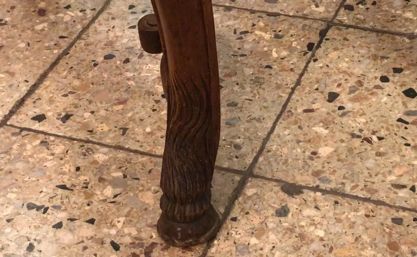 Base of antique chairs on a shiny stone floor.