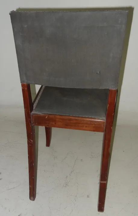 Rear view of an antique chair to restore, featuring wooden legs.