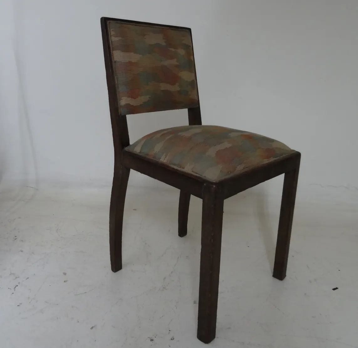 chaise ancienne avec un tissu coloré dans un cadre neutre