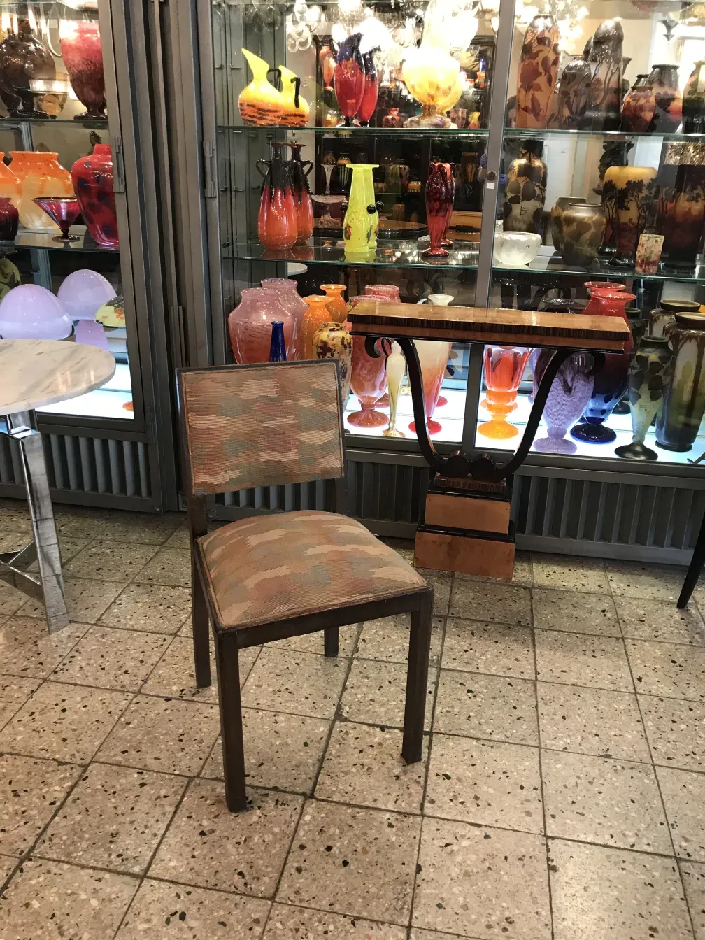 zwei antike Stühle in einer Umgebung mit bunten Vasen