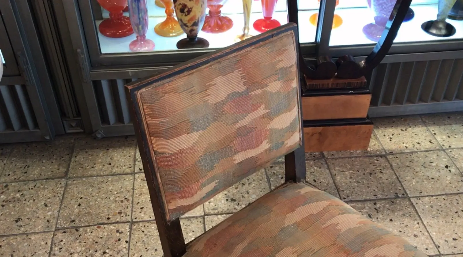 Antiker Art Deco Stuhl mit buntem Bezug in einer Vintage-Umgebung