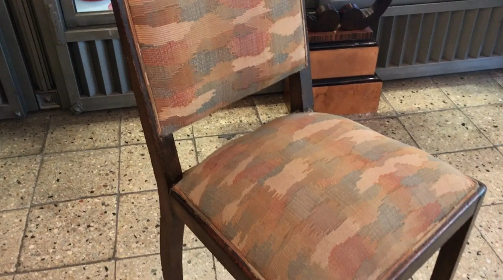 Silla antigua con tapizado colorido, ideal para restaurar en estilo Art Deco.