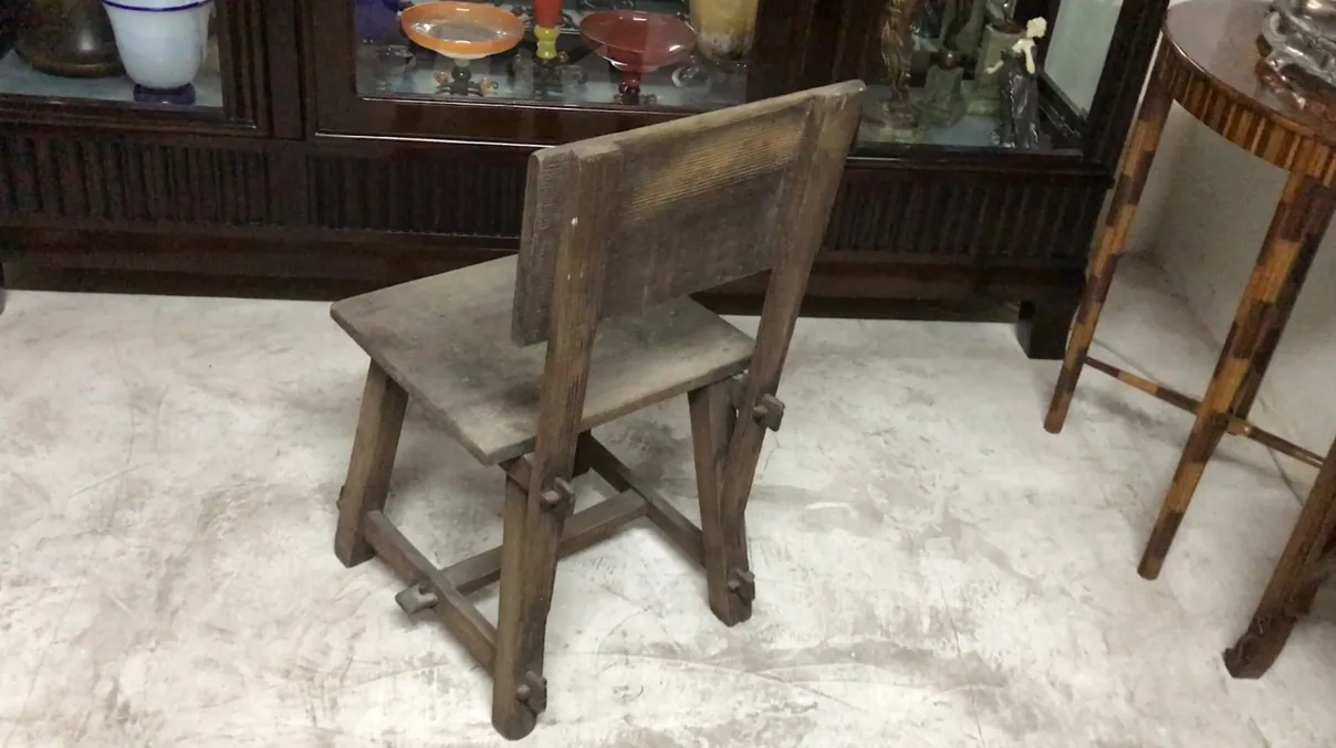 chaise ancienne de couleur brune avec un dossier droit dans un cadre rétro