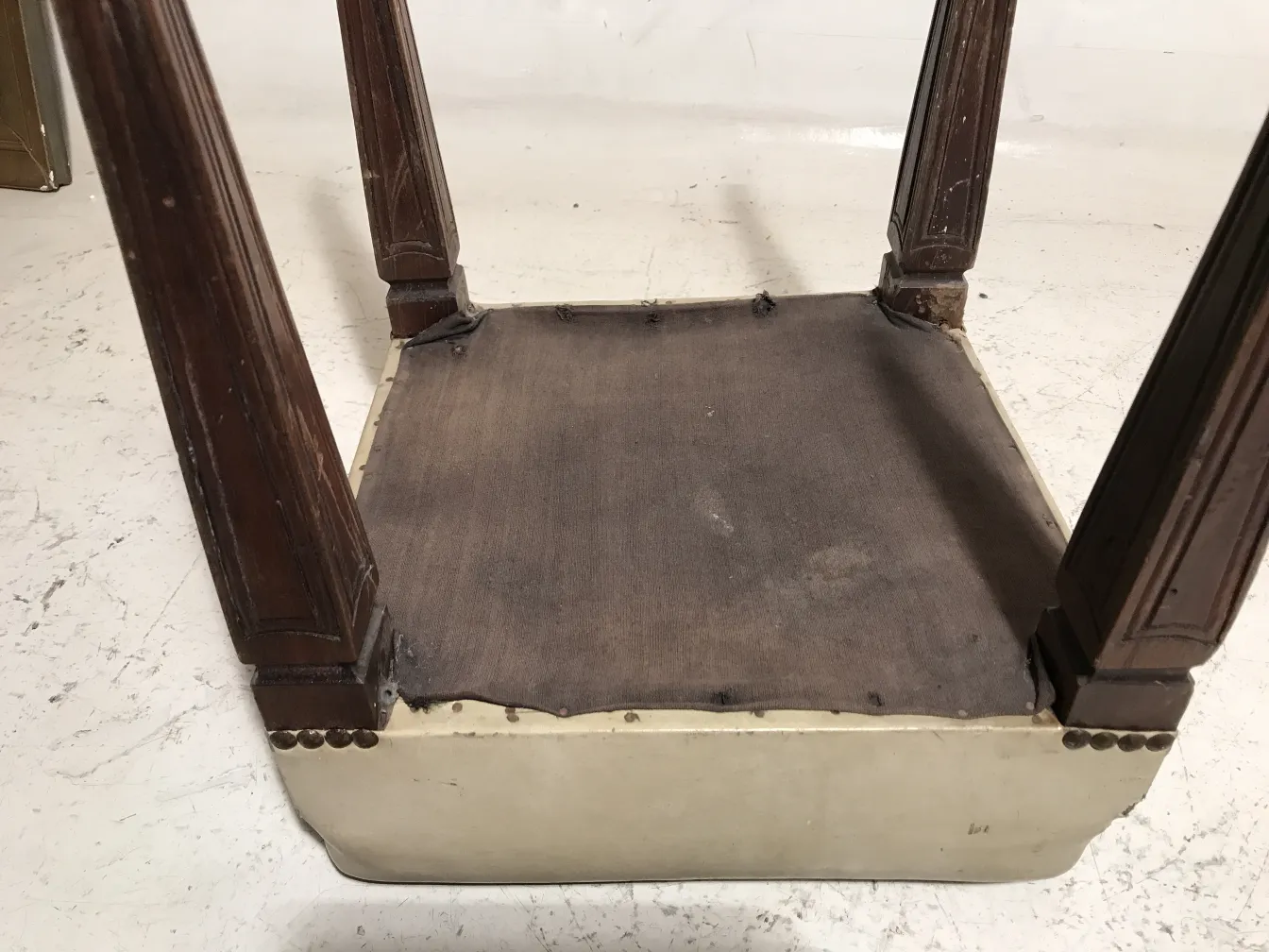 Ancien tabouret avec jambes sculptées dans un cadre classique