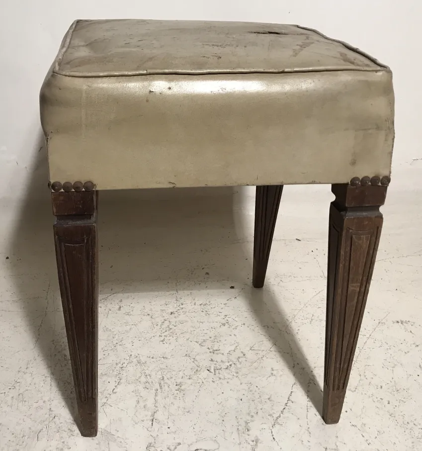 banqueta antiga com assento acolchoado e pernas de madeira decoradas