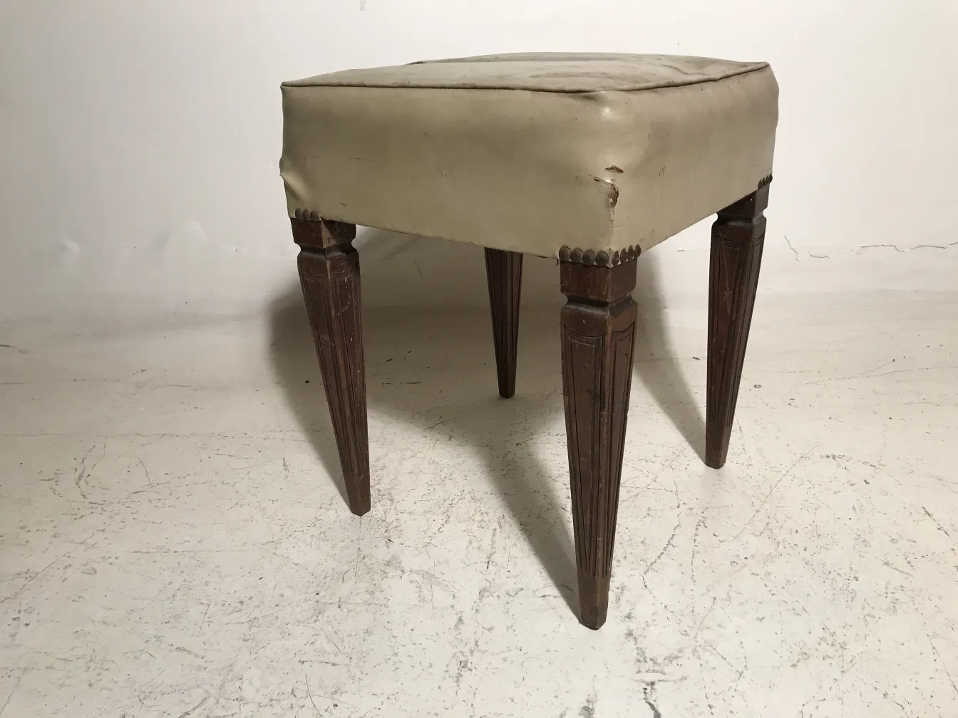 Sgabello antico quadrato con gambe elevate, perfetto per ambienti classici.