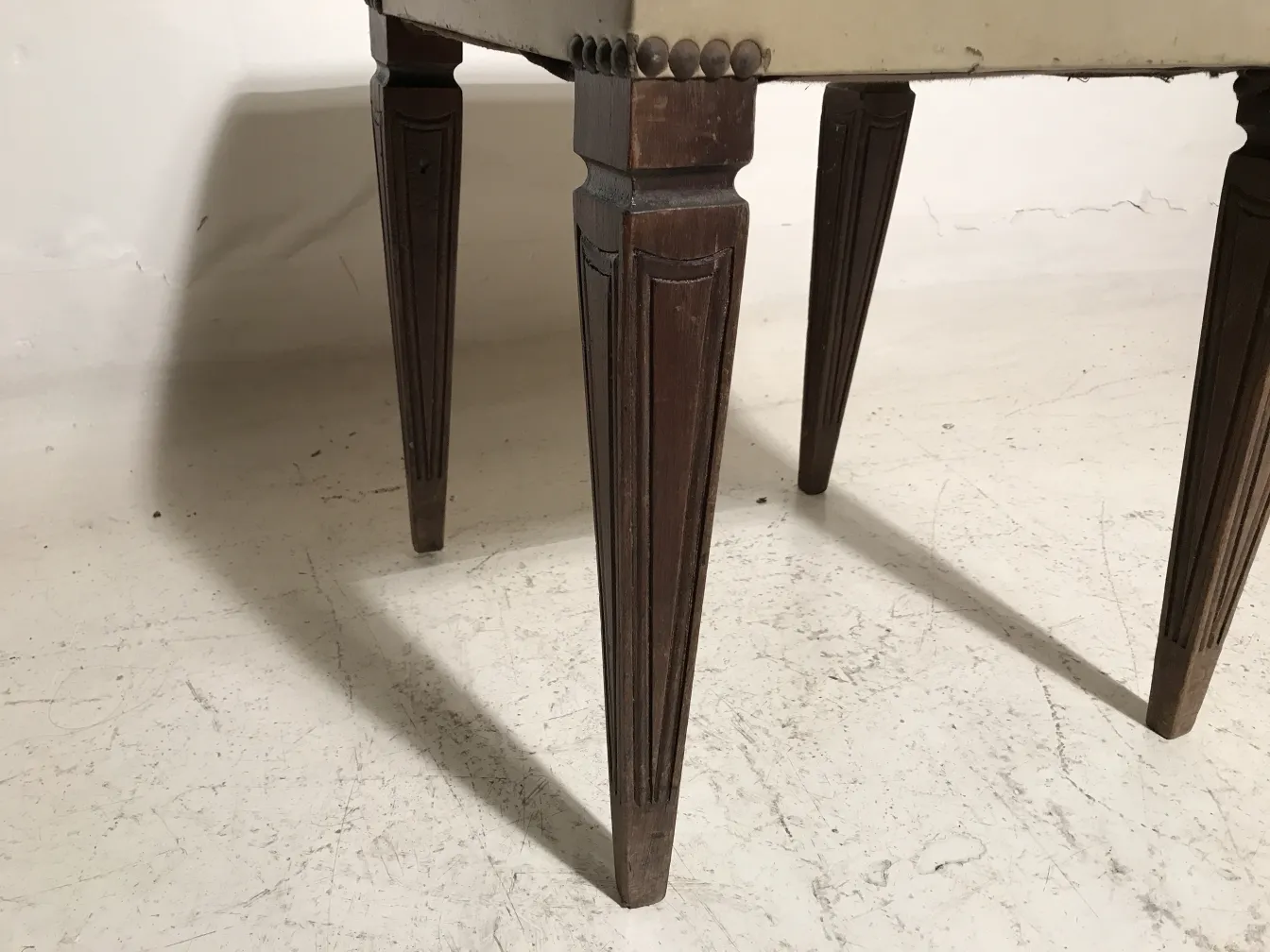 Antique sidewalk stool with decorative turned legs.