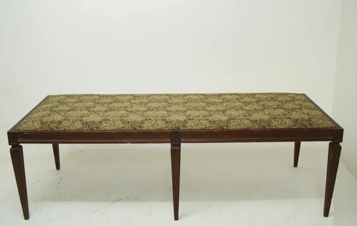 sgabello antico con tappezzeria floreale e gambe eleganti.