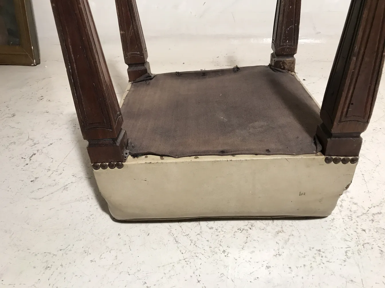 Tabouret ancien de style classique avec des pieds décoratifs.