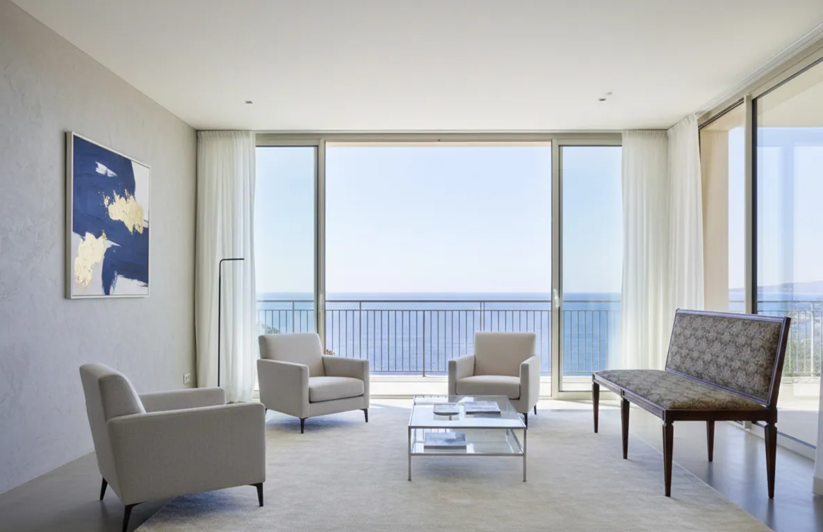 Banqueta antigua que complementa la decoración moderna. Parte de un ambiente con vista al mar.