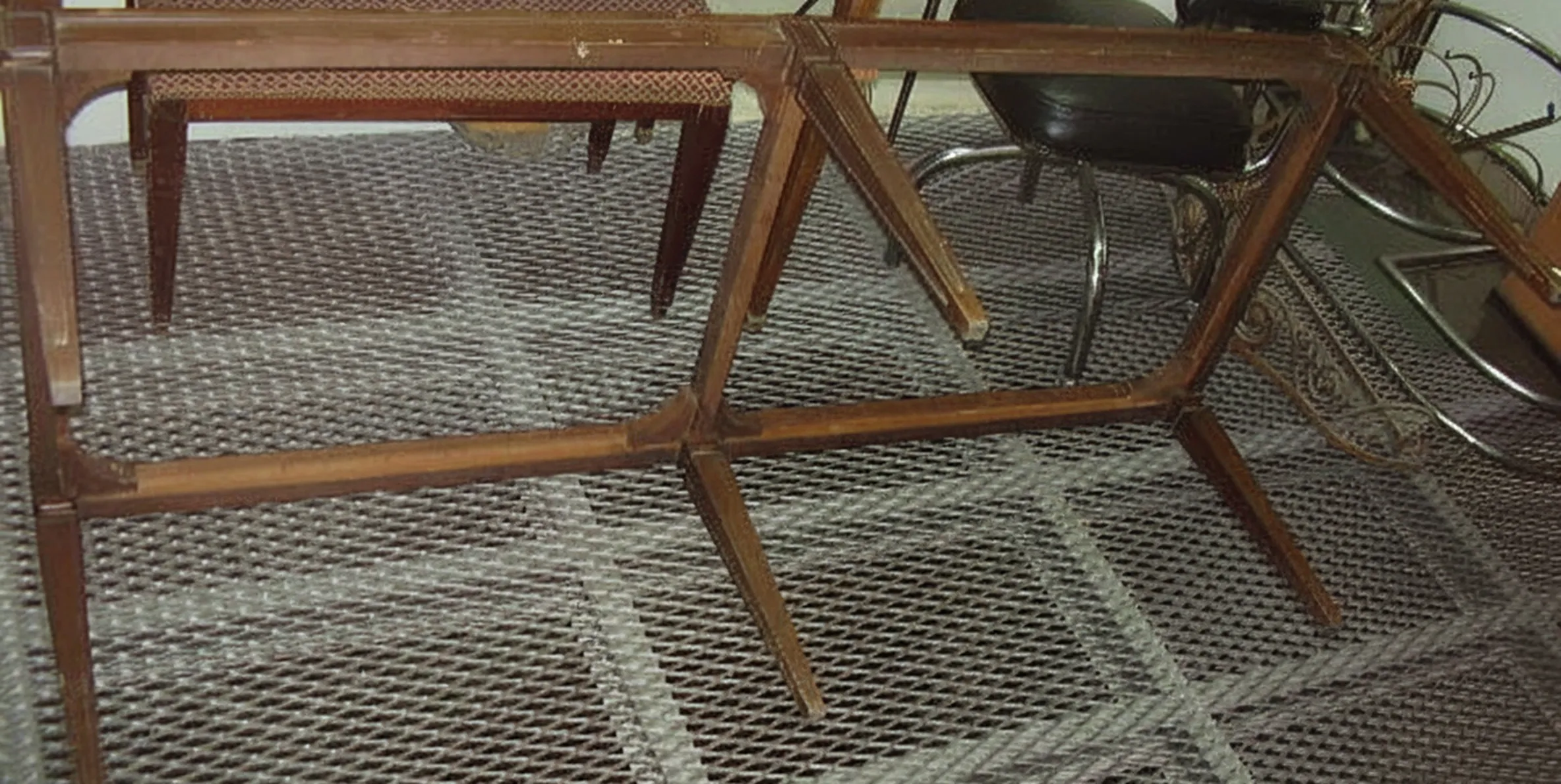 Sgabello antico in un ambiente classico con gambe angolari.