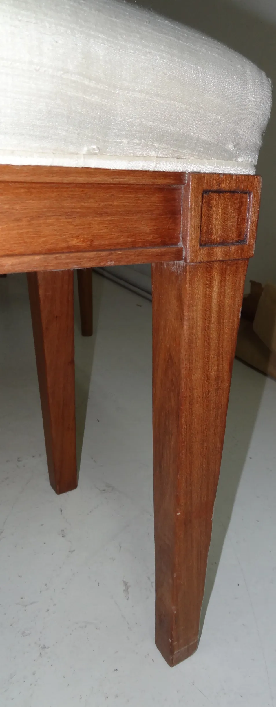 Vue latérale d'un ancien tabouret de rue avec des jambes droites et un design simple.