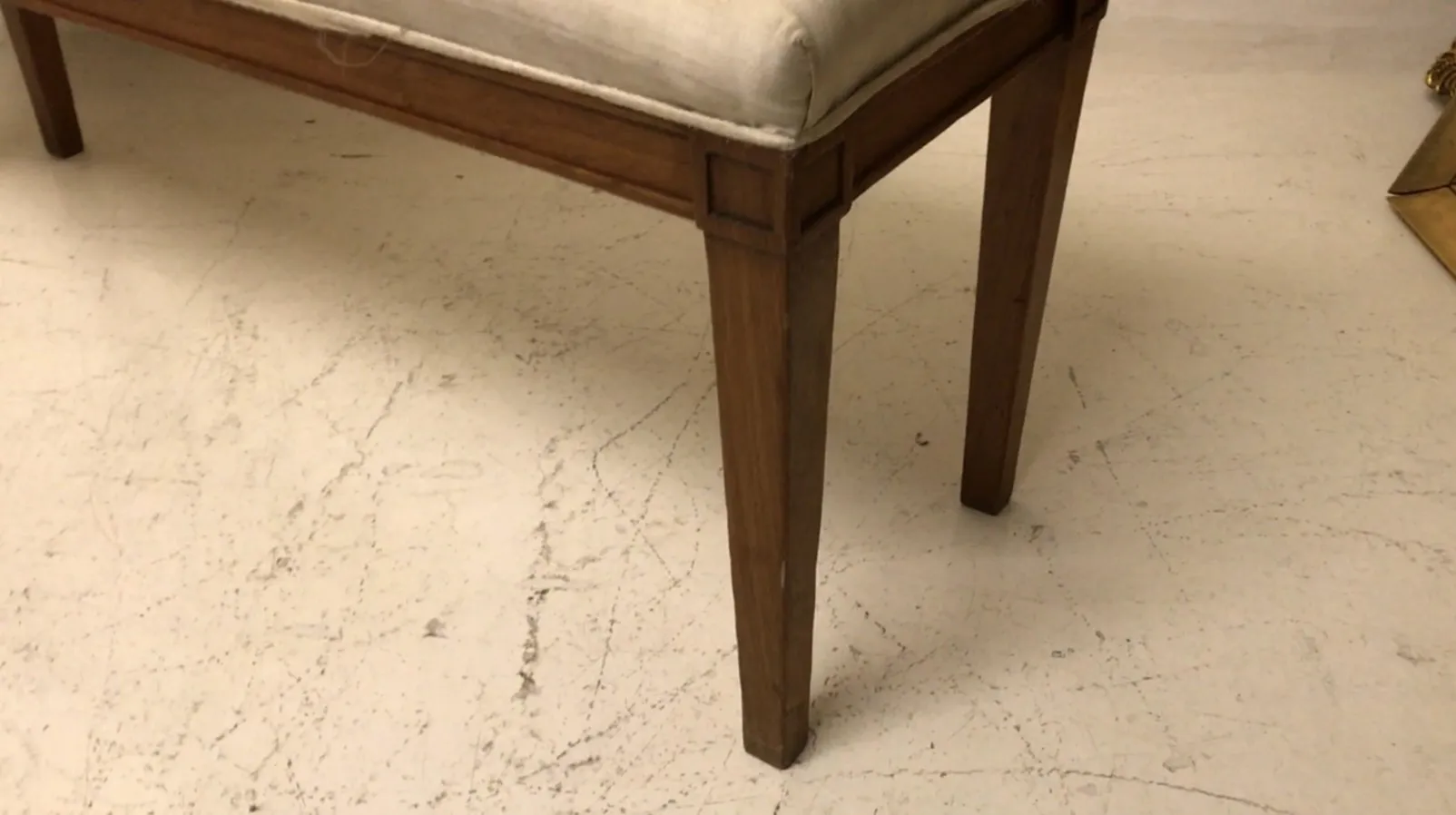 banqueta antiga com design simples, pernas retas em um ambiente claro