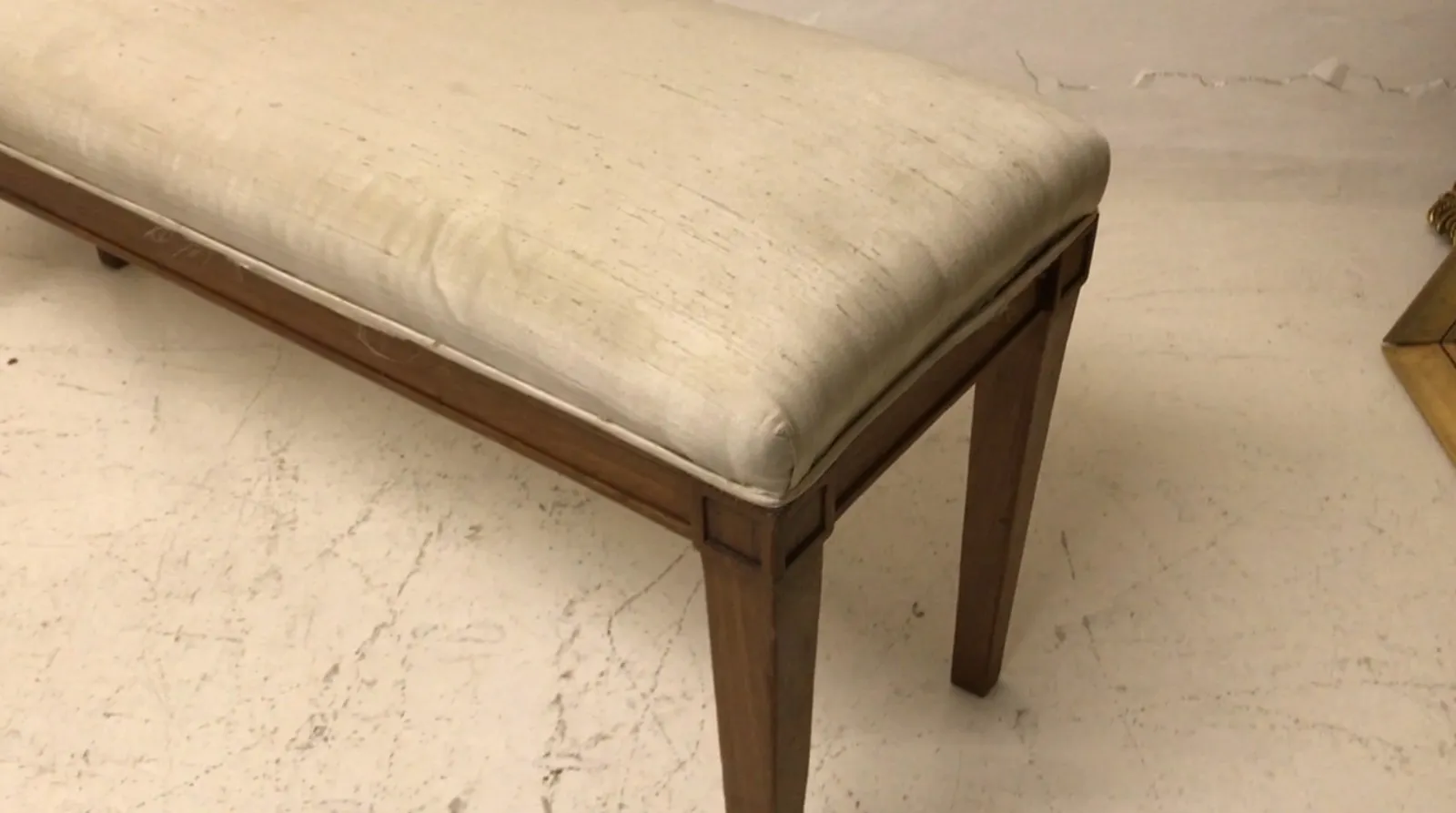 Sgabello antico con un design accogliente e confortevole, perfetto per qualsiasi ambiente. Presenta un sedile morbido e una struttura robusta in tonalità chiare.