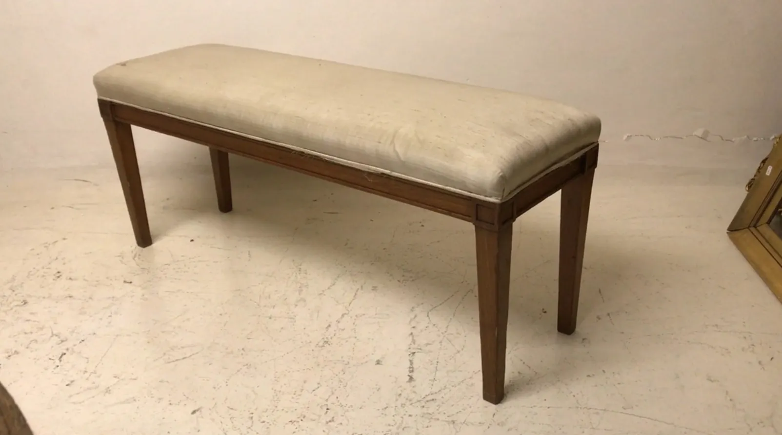 Tabouret ancien avec un rembourrage doux et des pieds élégants