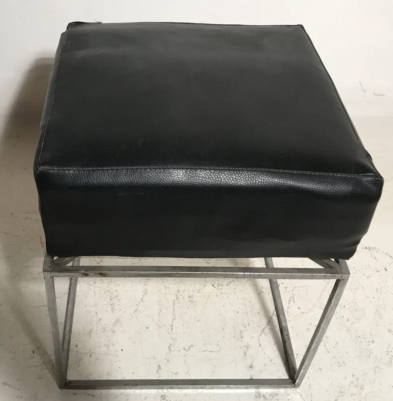 Banqueta antigua de estilo moderno en color negro con base metálica, ambiente sencillo