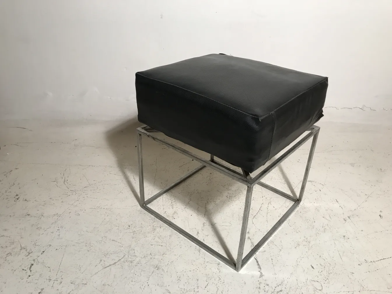 banqueta antigua de color negro con base metálica