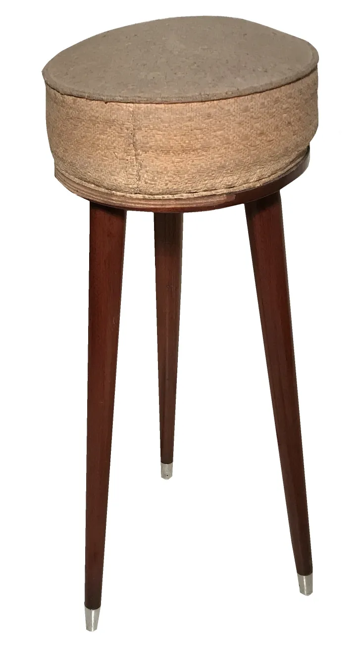 Antique three-legged stool in a cozy setting.