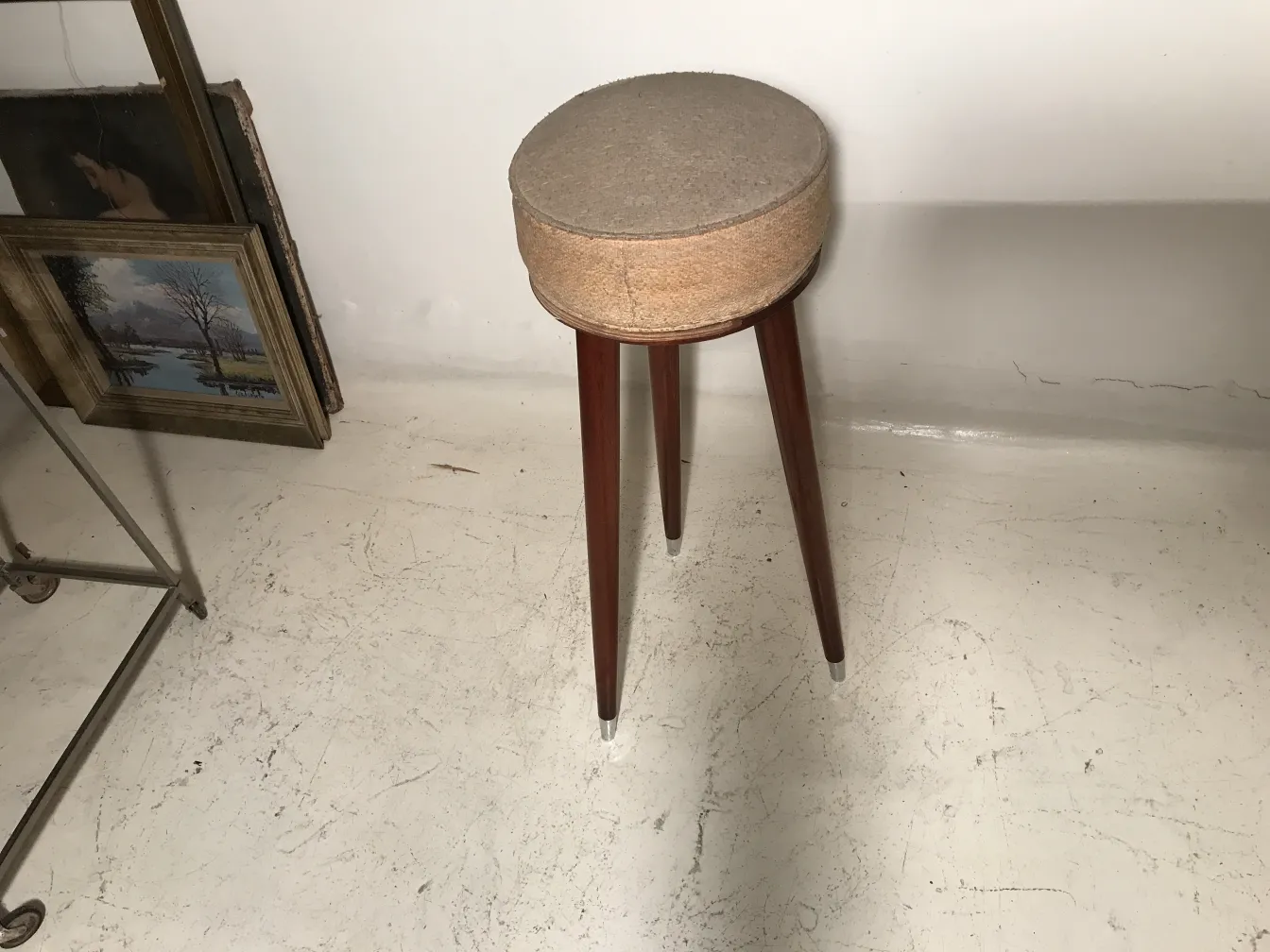 Tabouret ancien avec des pieds élégants dans un cadre classique.