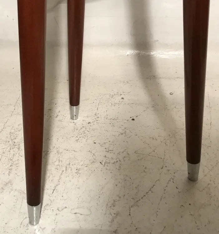 Vista delle gambe di un antico sgabello con design semplice.