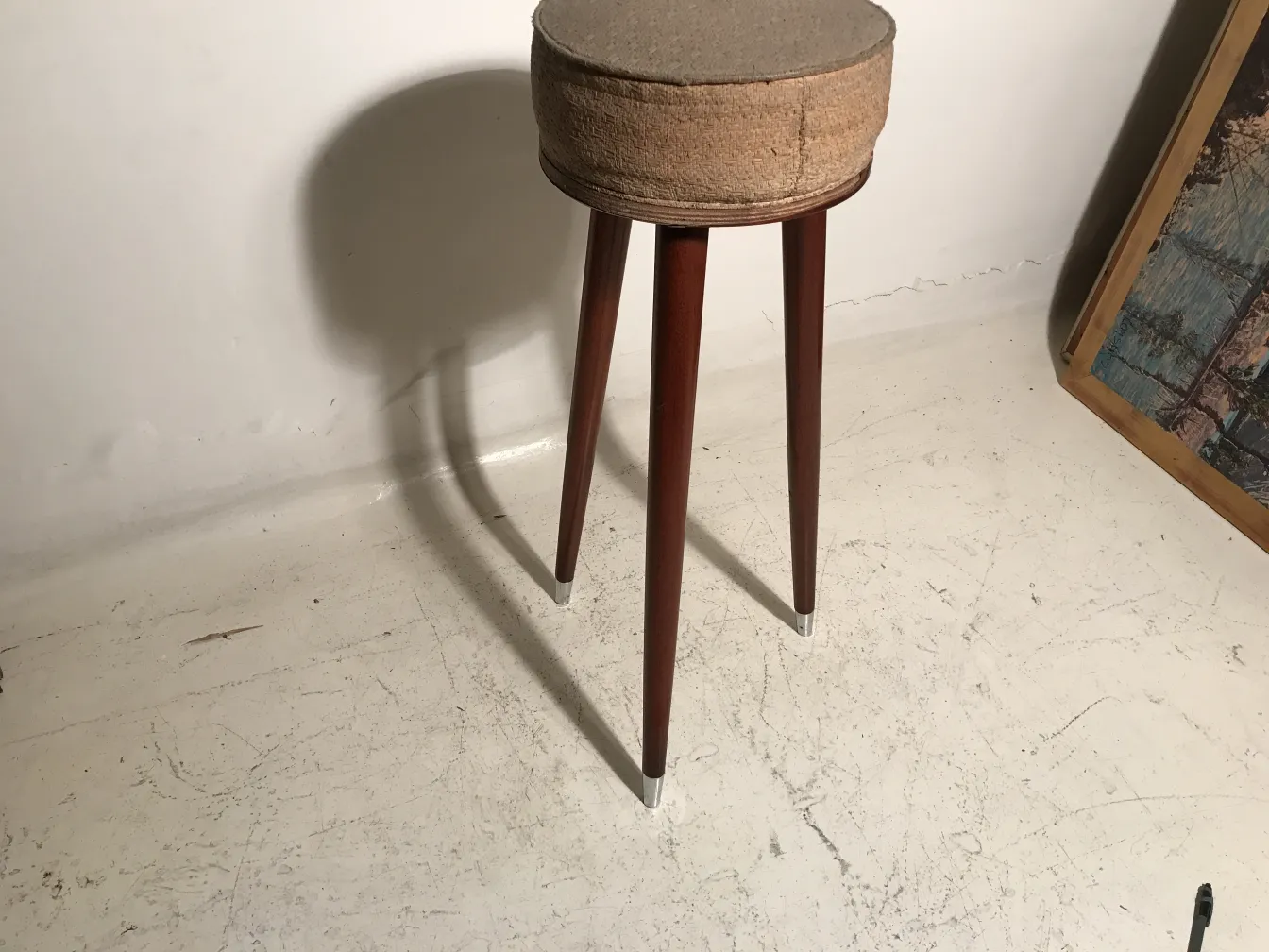 Banqueta antigua con patas largas, fondo neutro