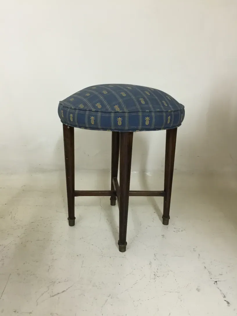 Tabouret ancien avec design bleu et pieds en bois, ambiance simple.