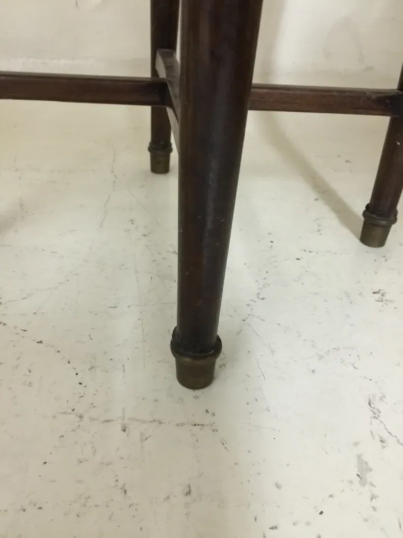 Tabouret ancien avec des pieds décoratifs dans un cadre neutre