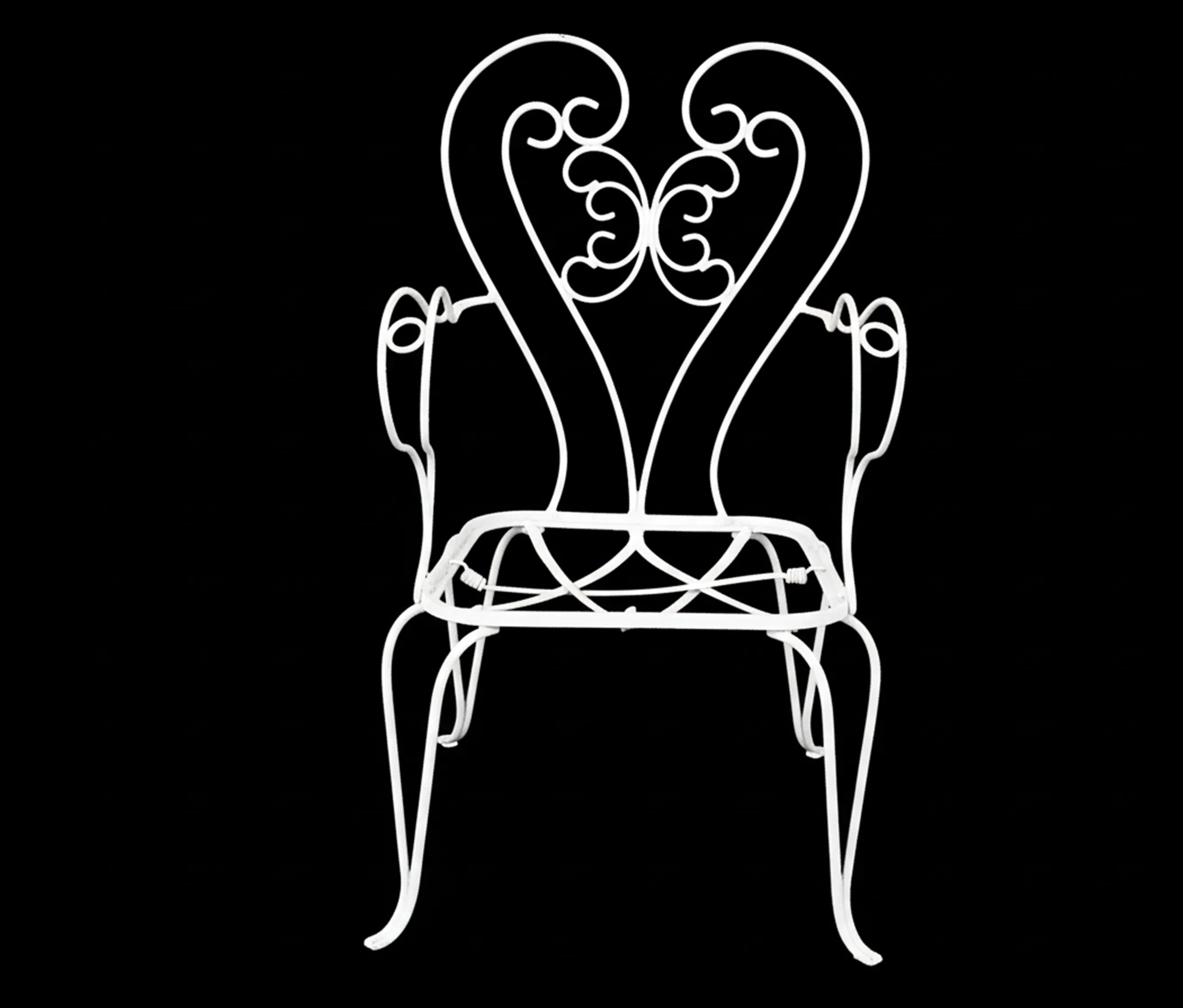 sillones de jardín antiguos de metal blanco con detalles ornamentales en un fondo negro