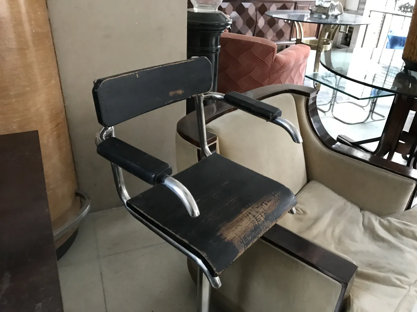 Silla antigua Breuer con brazos, acabado negro, ambiente elegante.