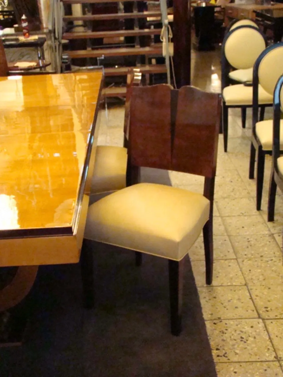 Antiker klassischer Sessel mit elegantem Design, umgeben von Stühlen und einem Tisch