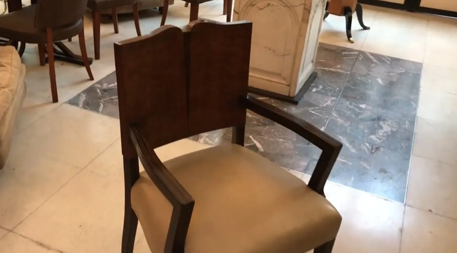 cadeirão antigo Art Deco com braços e estofado claro em ambiente elegante