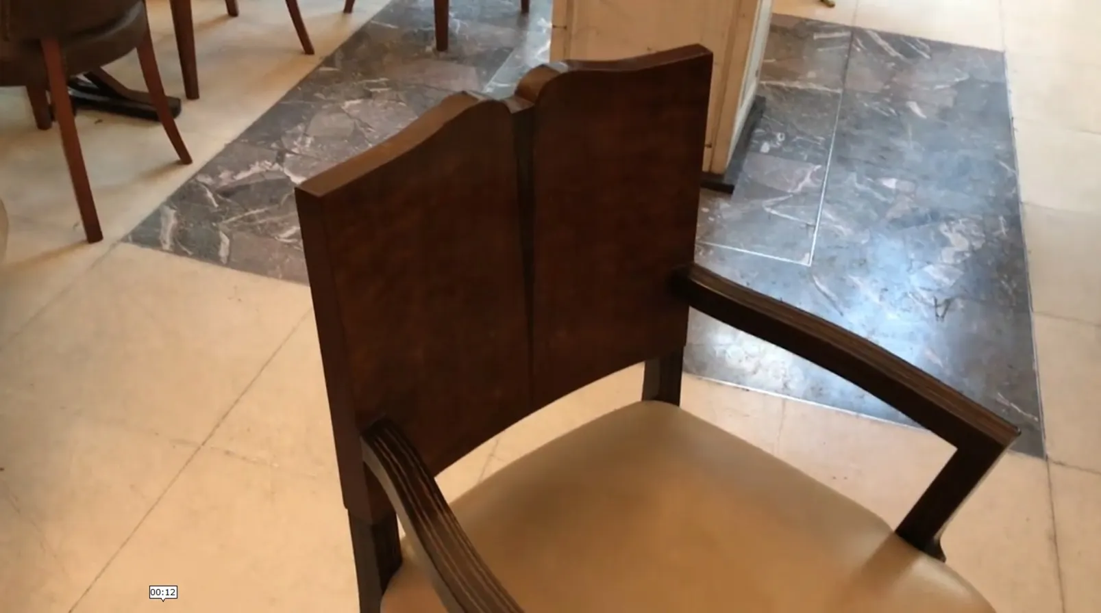 Sillón antiguo estilo Art Deco con diseño elegante y patas curvas.