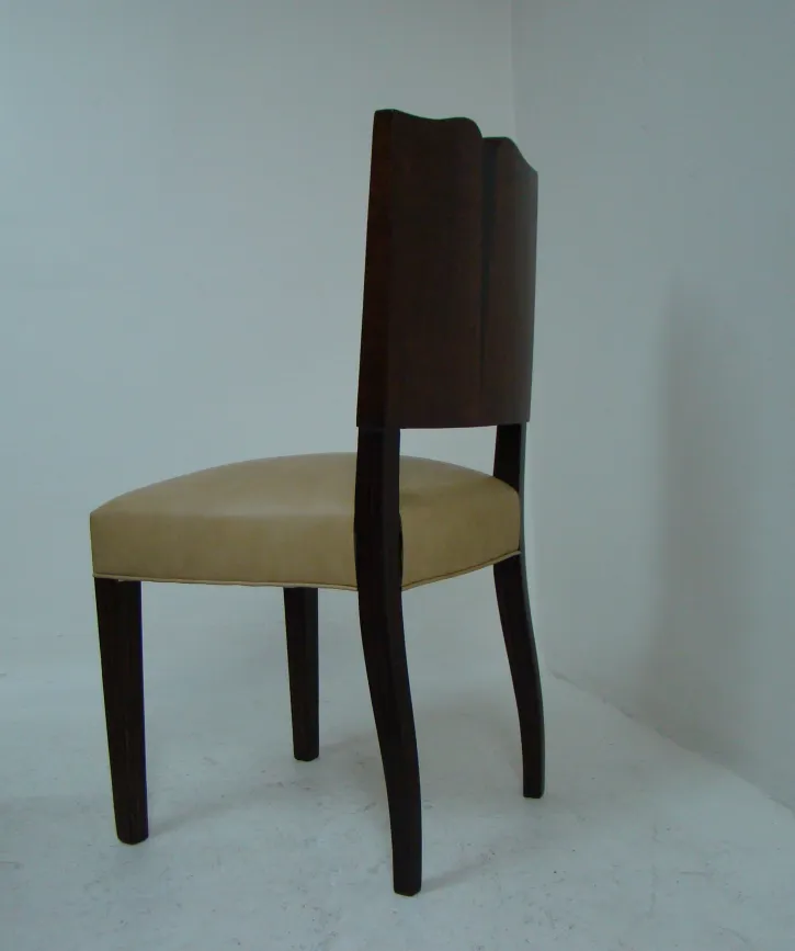 Vier antike Stühle mit elegantem Design in einem neutralen Umfeld.